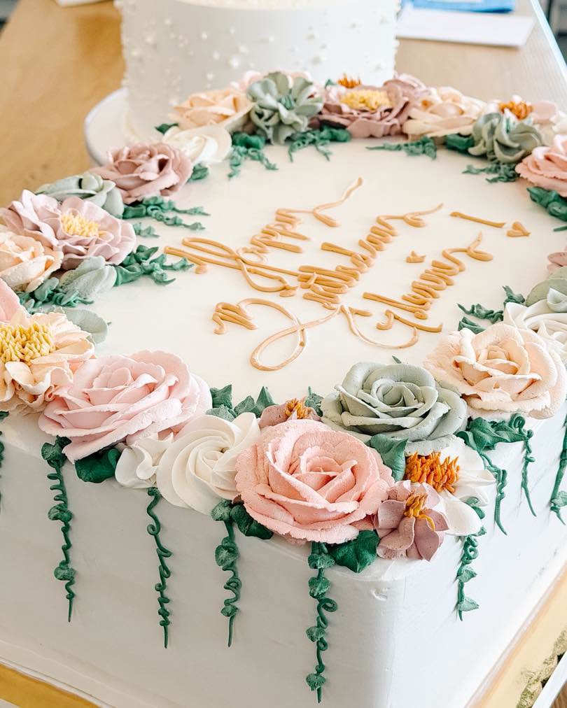 Floral wedding cake with text topper