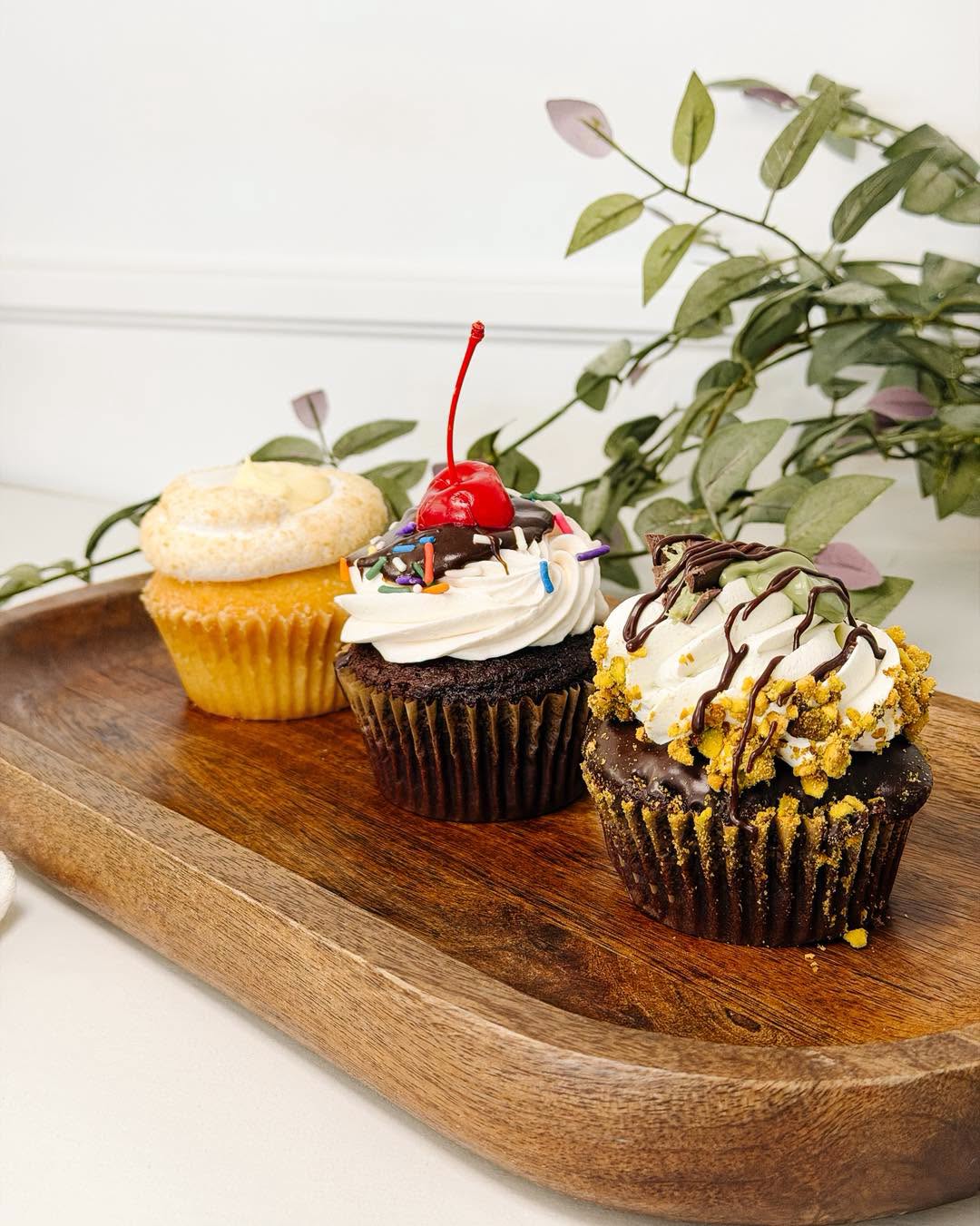 Decorated cupcakes on a wooden tray